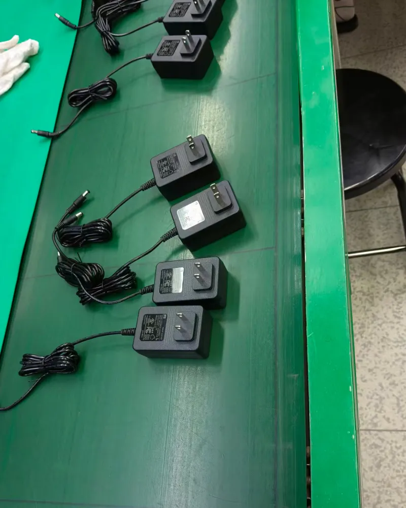 Mass production and batch control of PoE power adapters on a factory assembly line conveyor belt.
